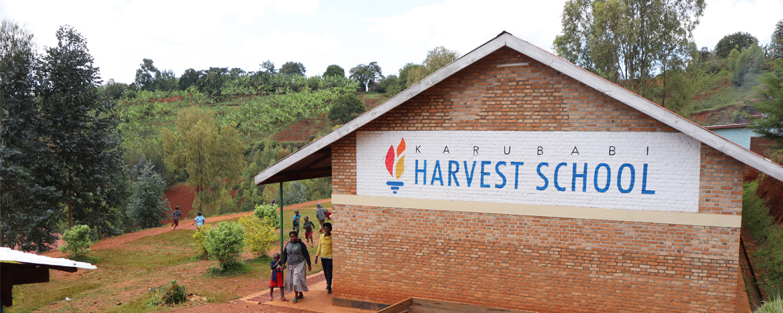 a view of a school building in the hills. The wall of the building says Karubabi Harvest School