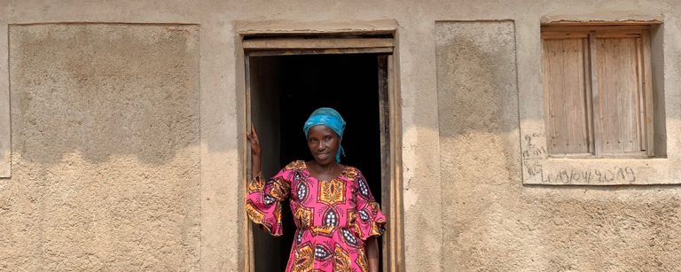 a woman stands in the doorway of her new house