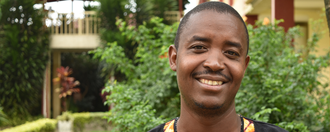 Jagen from YWAM Burundi smiles in a leafy courtyard