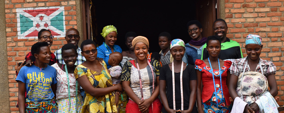 the ladies of the sewing class smile together outside their classroom