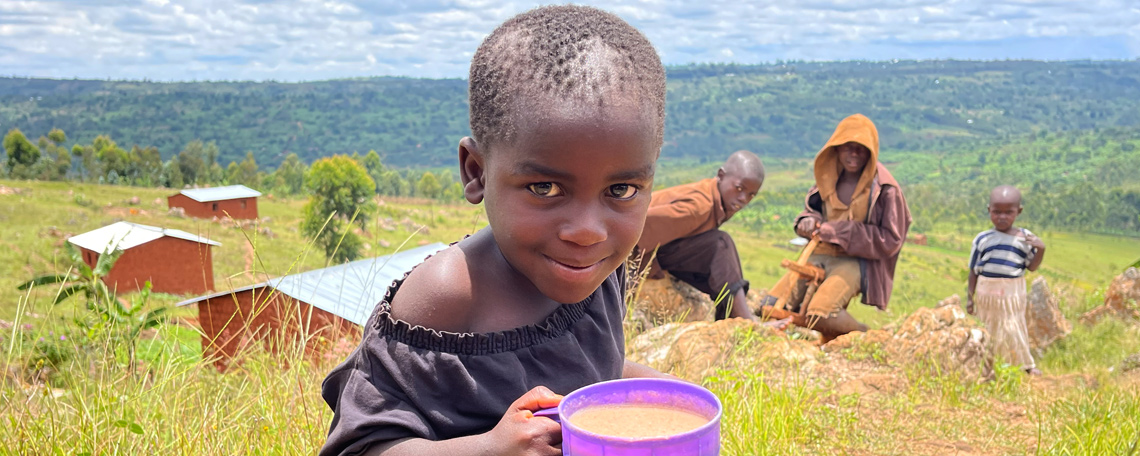 girl holds porridge smiling overlooking valley