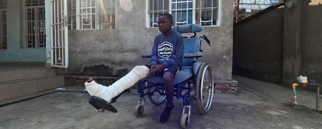 Issa sits in his wheelchair with a broken leg-new generation Burundi