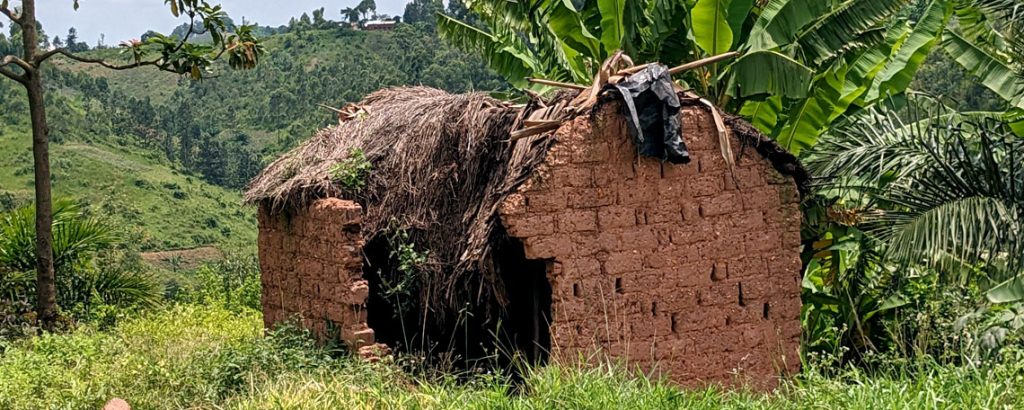 A mud hut damaged by weather with a collapsed roof and walls broken