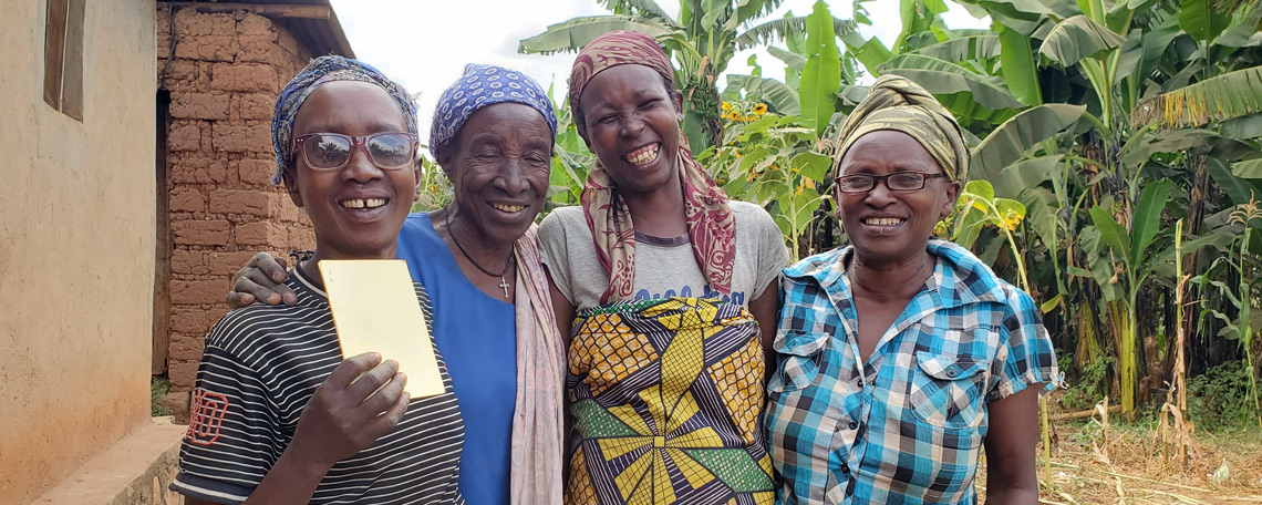 Annociate and three other ladies smiling together, one holds up a health insurance card.